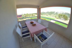 a dining room with a pink table and white chairs at Apartman Jadranka in Rab