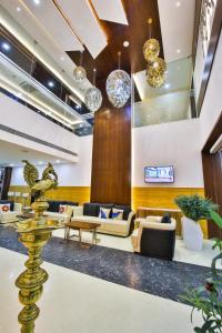 um lobby de um hotel com sofás e mesas em The Royal Grand em Karūr