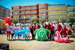 a group of people posing for a picture on the beach at Hotel Resort Marinella in Gabicce Mare