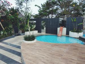 a swimming pool with a chair in a garden at WaitHozz in Beran-kidul