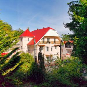 une grande maison blanche avec un toit rouge dans l'établissement BRILLWELLNESS, à Zalakaros