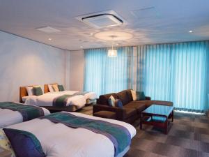 una habitación de hotel con 2 camas y una silla en Hotel Caretta, en Tatsugo