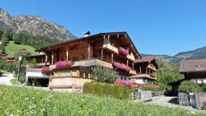 a wooden house with flowers on the side of it at Wellnessappartements Margit in Alpbach