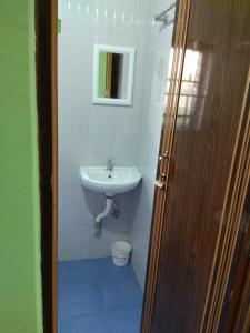a bathroom with a sink and a toilet and a mirror at Cozy Living in Guwahati