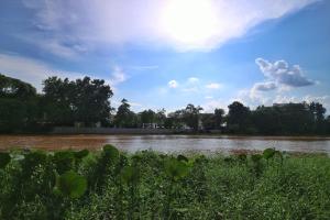 vistas a un río con el sol en el cielo en i-river chiangmai, en Chiang Mai