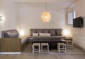 uma sala de estar com um sofá, uma mesa e bancos em Casa Boixader em Navás