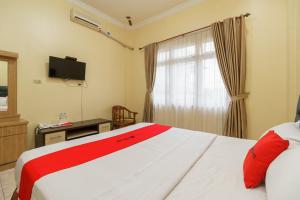Postel nebo postele na pokoji v ubytování RedDoorz Plus @ Hotel Sempurna Watervang Lubuk Linggau