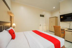 Postel nebo postele na pokoji v ubytování RedDoorz Plus @ Hotel Sempurna Watervang Lubuk Linggau