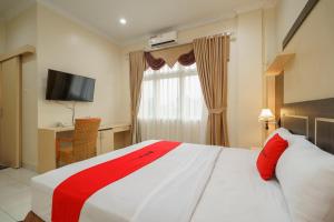 Postel nebo postele na pokoji v ubytování RedDoorz Plus @ Hotel Sempurna Watervang Lubuk Linggau