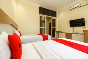 Postel nebo postele na pokoji v ubytování RedDoorz Plus @ Hotel Sempurna Watervang Lubuk Linggau