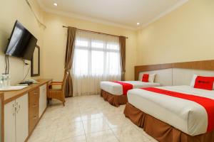 Postel nebo postele na pokoji v ubytování RedDoorz Plus @ Hotel Sempurna Watervang Lubuk Linggau
