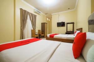 Postel nebo postele na pokoji v ubytování RedDoorz Plus @ Hotel Sempurna Watervang Lubuk Linggau