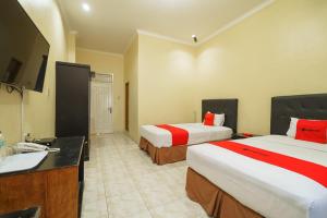 Postel nebo postele na pokoji v ubytování RedDoorz Plus @ Hotel Sempurna Watervang Lubuk Linggau
