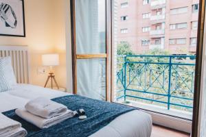a bedroom with a bed and a large window at Sani apartment by People Rentals in Bilbao