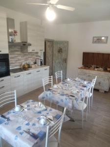 una sala da pranzo con tavolo e sedie e una cucina di B&B Marcello & Francesca a Urbino