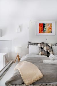 a white bedroom with a bed and a painting on the wall at Exclusive Downtown Bella Home in Budapest