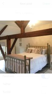 a bedroom with a large bed with wooden beams at Chez Broche in Mazerolles