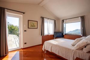 a bedroom with a bed and two large windows at Il Leccio - Luxury Resort Portofino Monte in Santa Margherita Ligure
