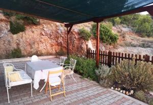 a patio with a table and chairs under a canopy at Porto Katsiki Blu in Athani