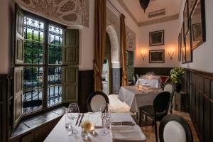 a restaurant with tables and chairs and windows at Le Farnatchi in Marrakech