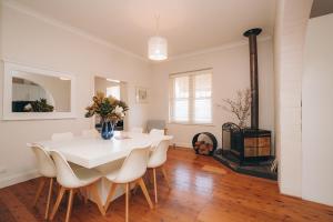 a dining room with a table and chairs and a fireplace at The Mudgee Merlot Gate Guesthouse in Mudgee