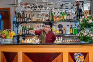 ein Barkeeper, der einen Drink an einer Bar macht in der Unterkunft Oscar Saigon Hotel in Ho-Chi-Minh-Stadt
