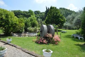 a garden with three stone statues in the grass at Resort La Mola in Sommacampagna