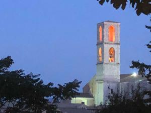 un edificio con una torre con una luz naranja. en Speciosa 3 - Casa degli Artisti, en Perugia