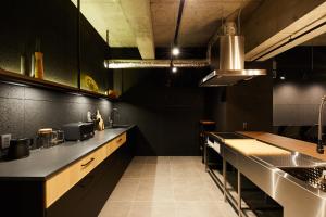 a kitchen with black walls and a counter top at ZONK HOTEL Nakasu-Deaibashi in Fukuoka