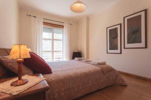 1 dormitorio con 1 cama con lámpara y ventana en Best Houses 11 - Surf Baleal, en Peniche