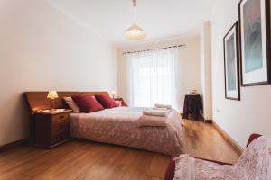 1 dormitorio con 1 cama con almohadas rojas en Best Houses 11 - Surf Baleal, en Peniche