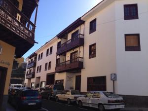 Apartamento La Penca 3 Garachico في غاراتشيكو: مجموعة سيارات متوقفة أمام مبنى