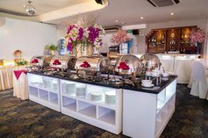 a buffet in a restaurant with plates and flowers at Oscar Saigon Hotel in Ho Chi Minh City