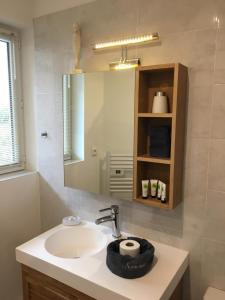 a bathroom with a sink and a mirror at Villa L'Amiraute in Agde