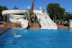 a water slide in a pool with people on it at Camping Platja Cambrils in Cambrils