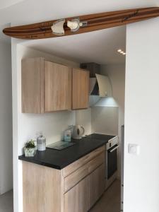 a kitchen with wooden cabinets and a black counter top at Villa L'Amiraute in Agde