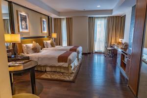a large hotel room with a bed and a desk at Somerset Greenways Chennai in Chennai