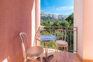 a table and two chairs on a balcony with a view at Apartments Nada in Baška