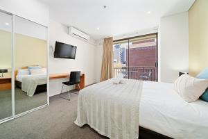 Habitación de hotel con cama y balcón en All Suites Perth en Perth
