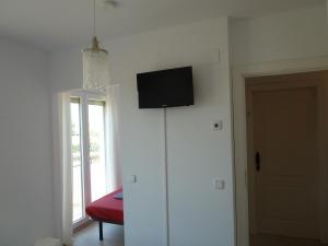 Habitación con TV de pantalla plana en la pared en Hostal Moratinos, en Moratinos