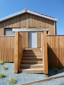 a wooden building with a staircase in front of it at L ABRI spa et détente in Liergues