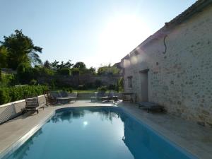 a swimming pool next to a building with a patio at Casa la Rosa & Spa in Courdimanche-sur-Essonne