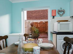 a kitchen with a table with plates and a microwave at Bayfields house by the Sea, parking, garden, central location in Portsmouth