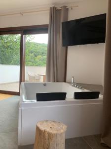 Una gran bañera blanca con un televisor encima. en Al bosco incantato en Trieste