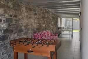 a living room with a couch and a foosball table at OurMadeira - CalhetaScape, informal in Calheta