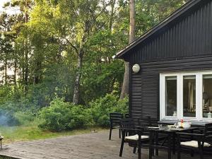 a patio with a table and chairs next to a cabin at 4 person holiday home in Læsø-By Traum in Læsø