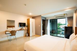 a bedroom with a large bed and a balcony at Jira Boutique Residence in Chiang Mai
