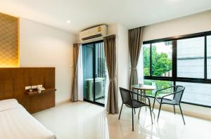 a bedroom with a bed and a table and chairs at Jira Boutique Residence in Chiang Mai