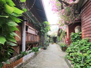 un callejón en un jardín con plantas y flores en OYO 44084 Ombak Inn Chalet, en Pangkor