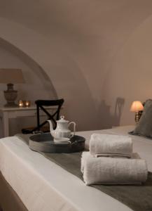 a bed with towels and a tea kettle on it at Casa Teresinella in Torre Annunziata